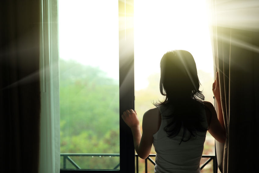 Girl Opening Curtain to Sunlight | Atlanta Skylights